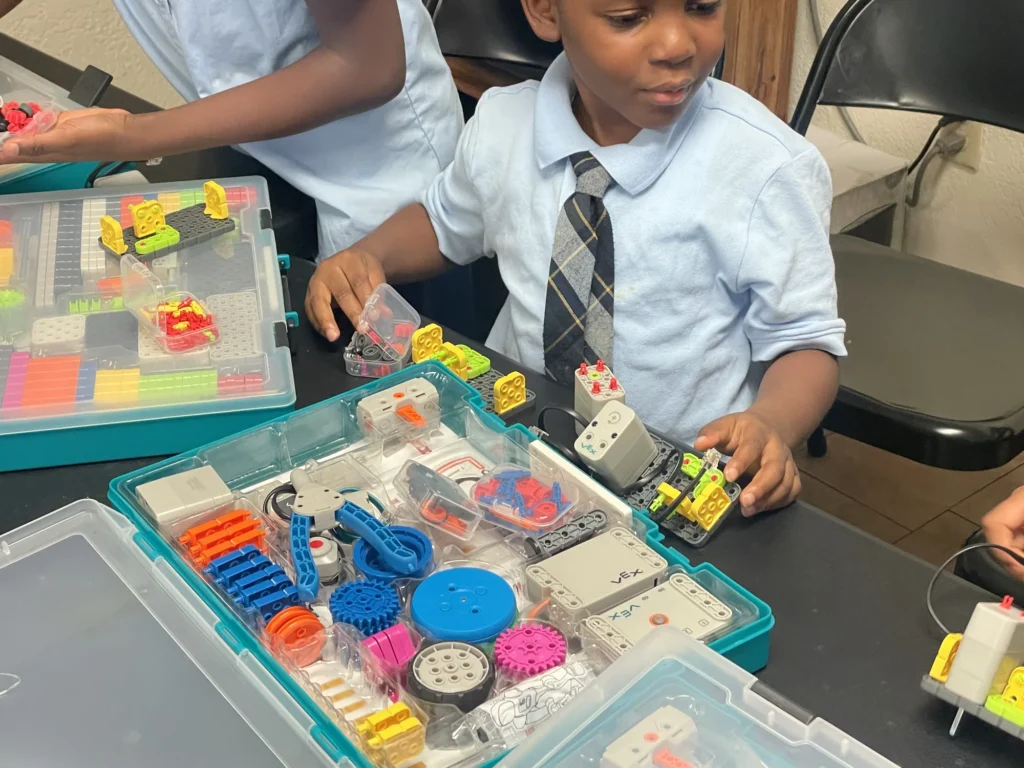 Young Illuminate STEM students building together with a robotics kit